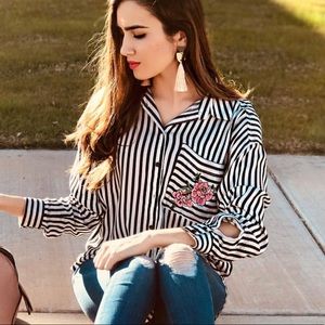 Striped long sleeve shirt with flower logo.
